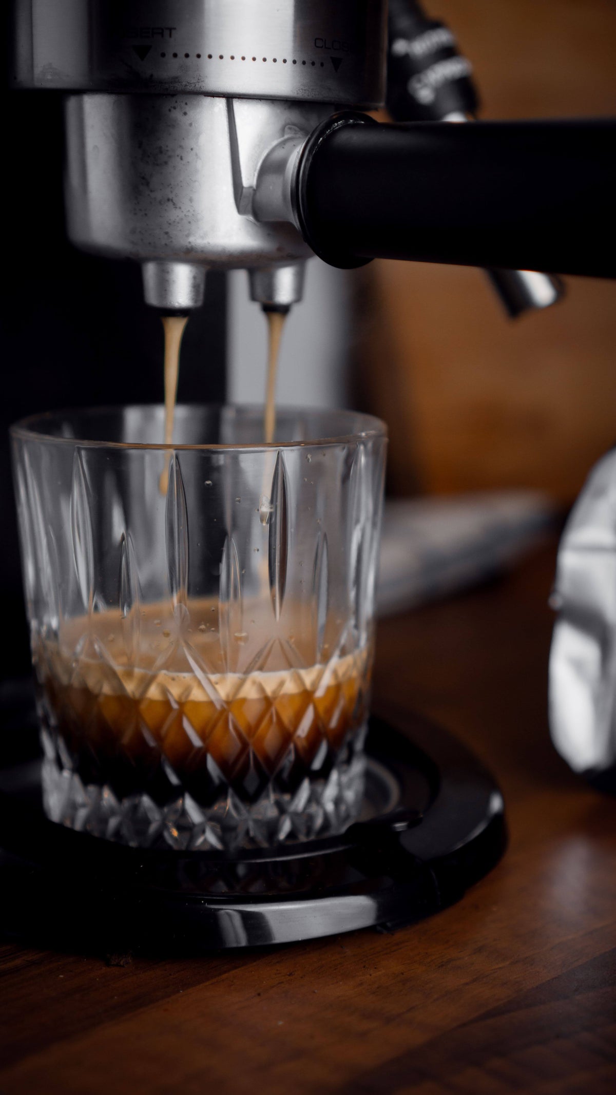 Espresso läuft aus dem Siebträger mit zwei Ausläufen in ein Kristallglas